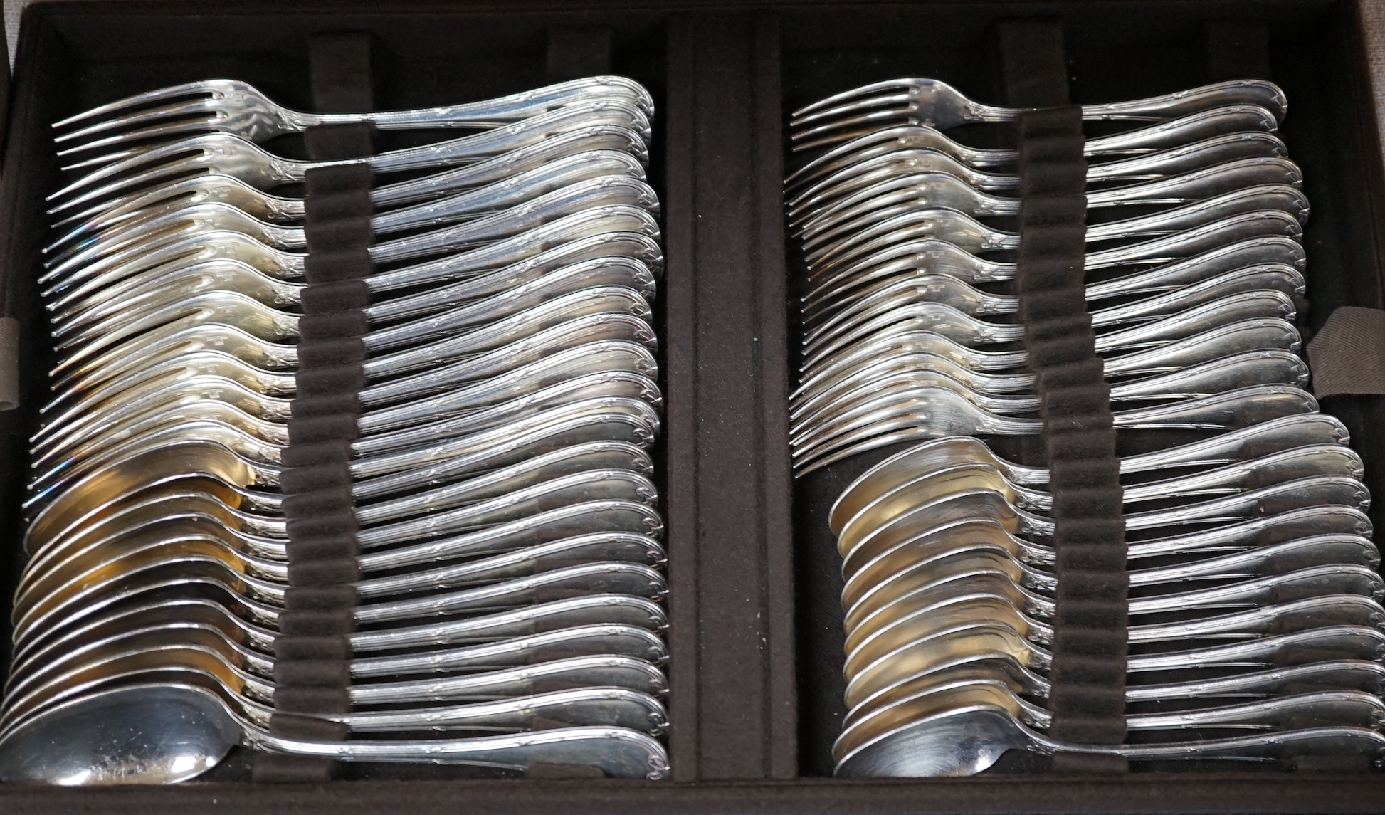 A cased canteen of French Christofle silver plated bow pattern cutlery, a twelve piece setting contained within two layers, case 49.5cm wide, 31cm deep, 13.5cm high